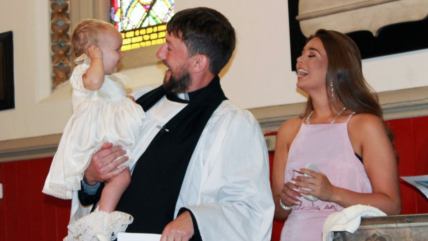 Vicar christening a child